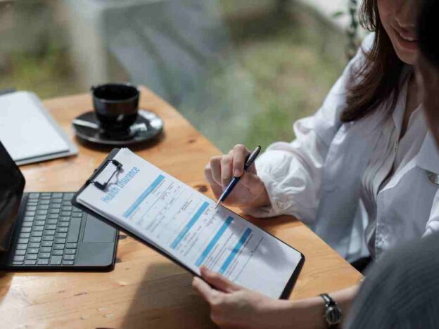 Patient Navigator show client clipboard with health insurance paperwork.