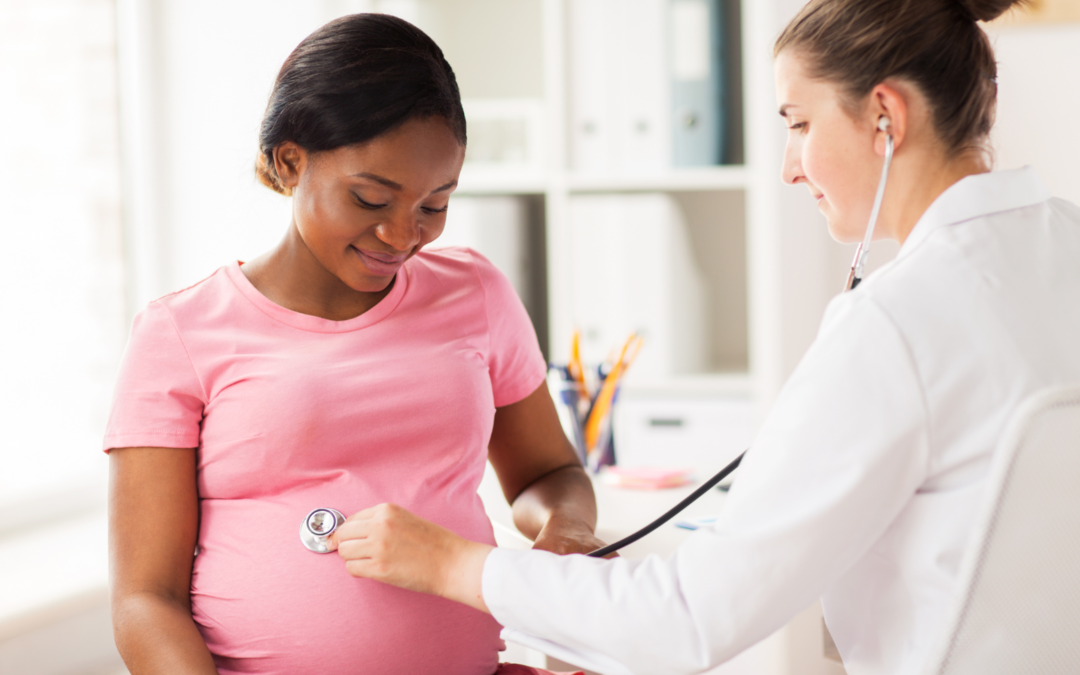 A female doctor using a stethoscope on a pregnant patient. 